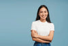 Smiling woman in white t-shirt with crossed arms posing on blue background